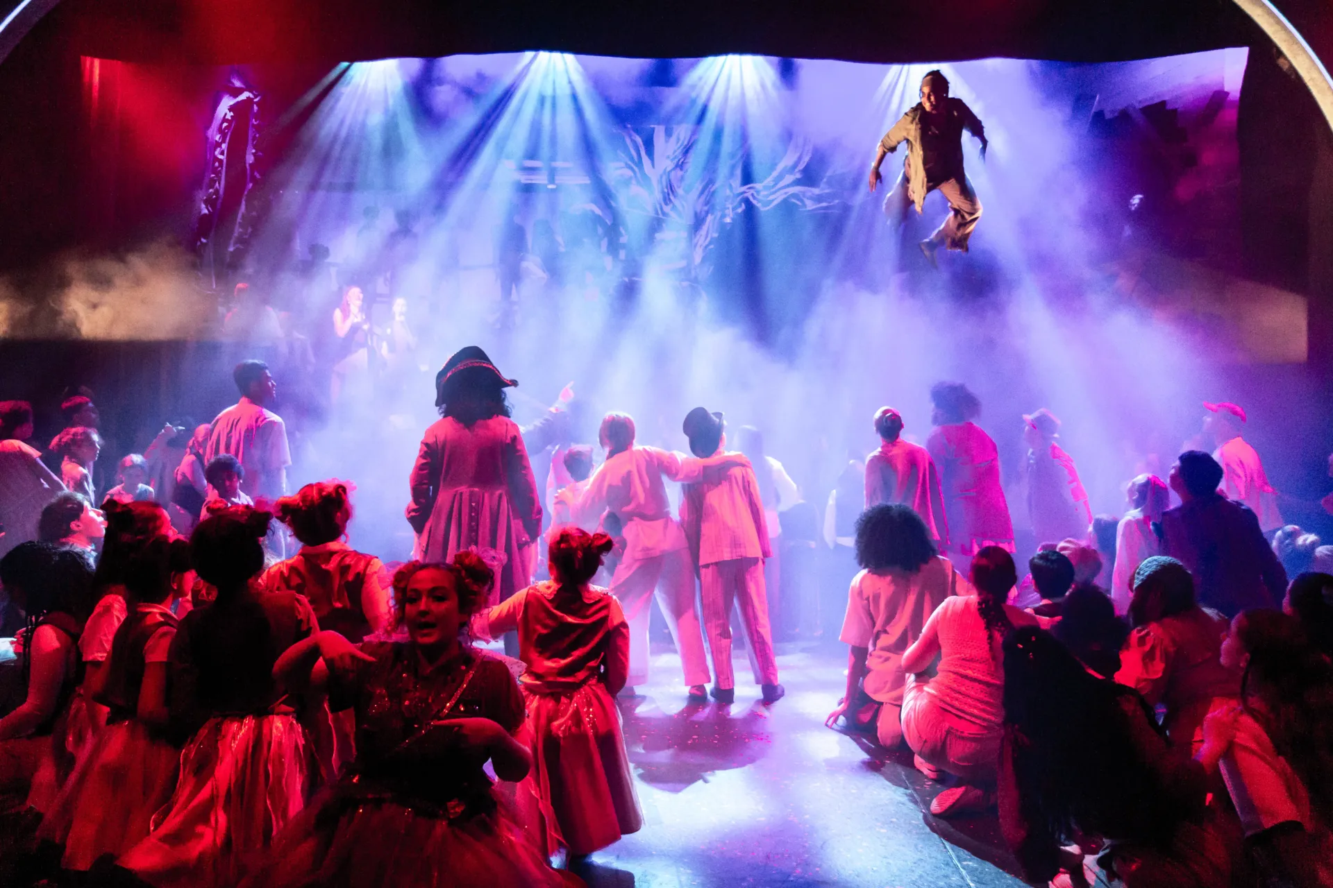 Peter Pan flying over the cast on stage