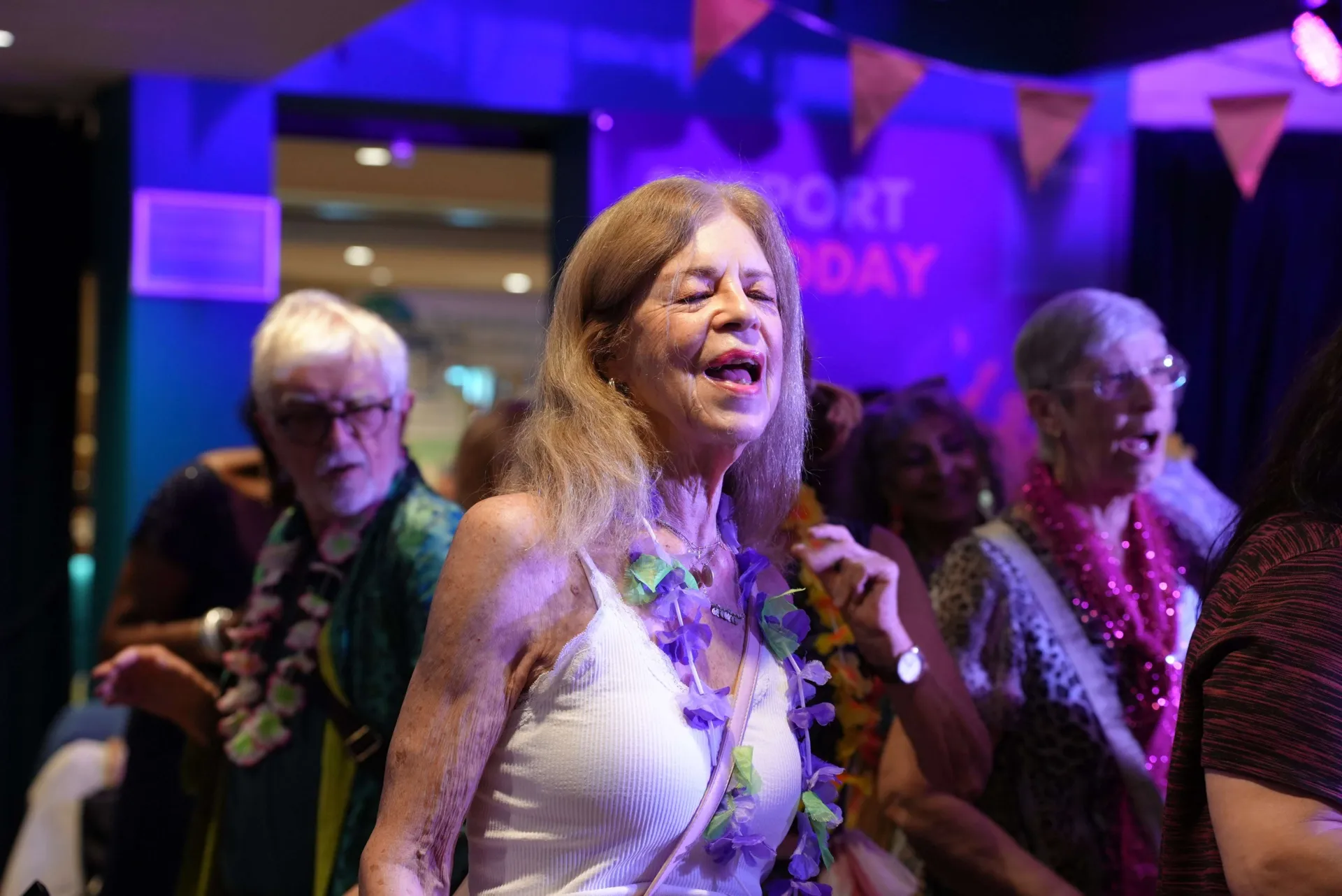 Gladrags members singing and dancing together on the dancefloor