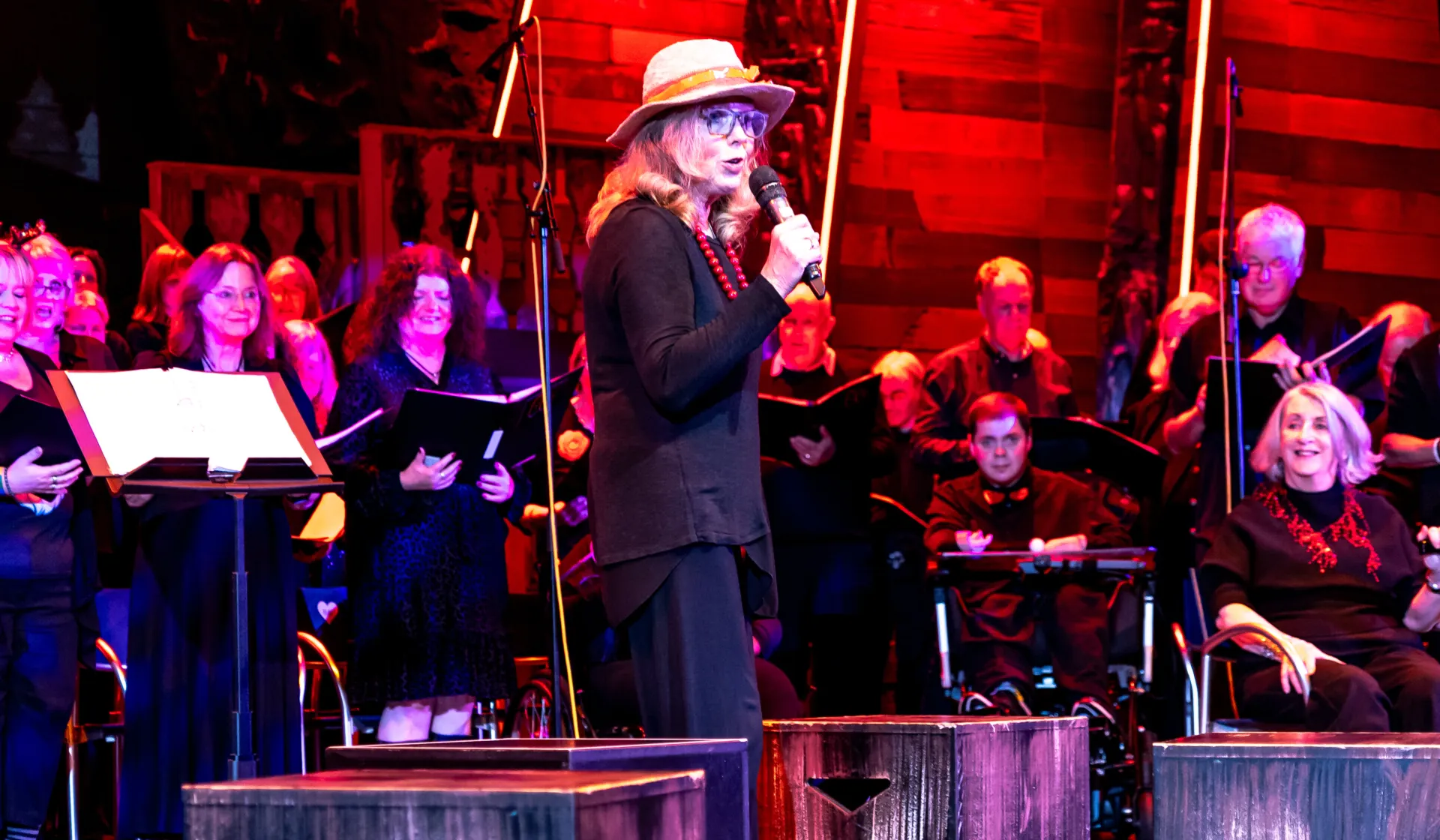 Lady on a microphone in front of a choir