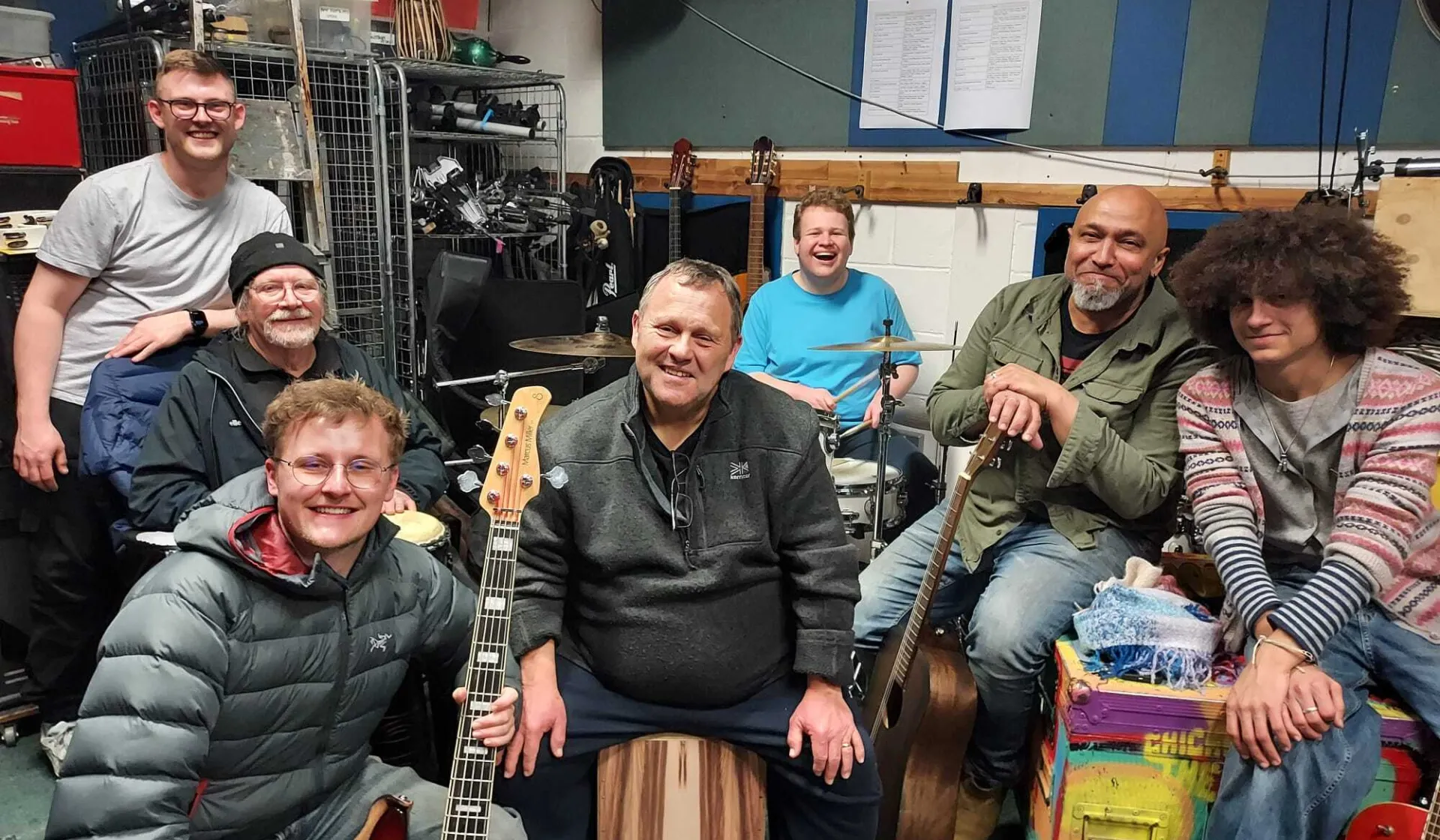 A group of musicians sitting together with instruments