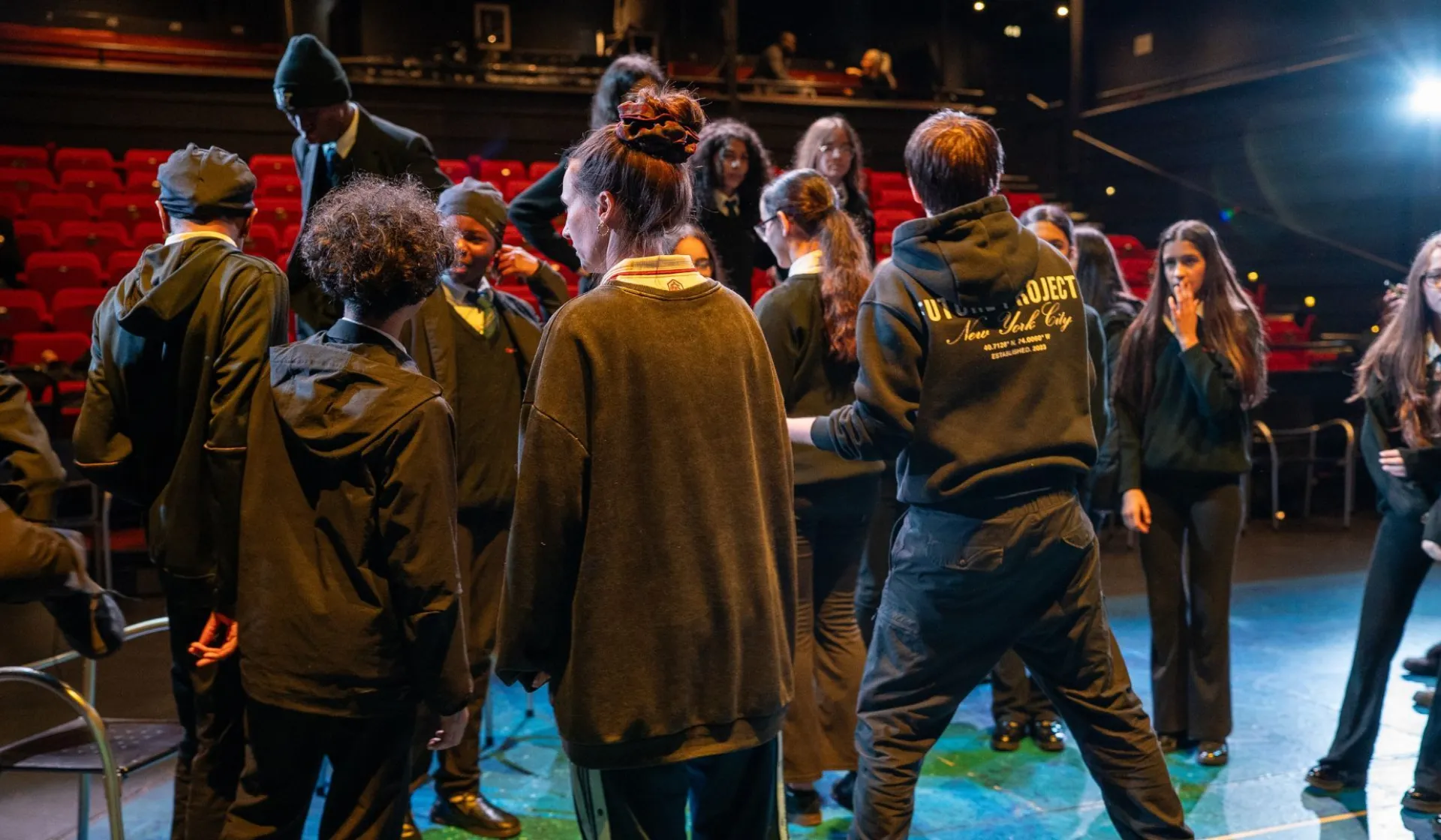 A group of school kids being taught drama