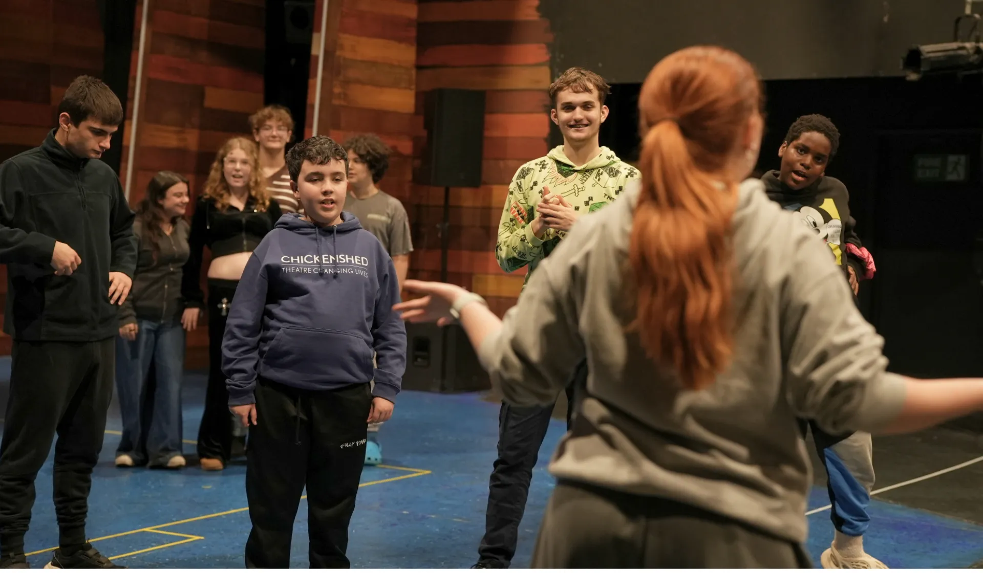 A group of children 11-18 acting on stage