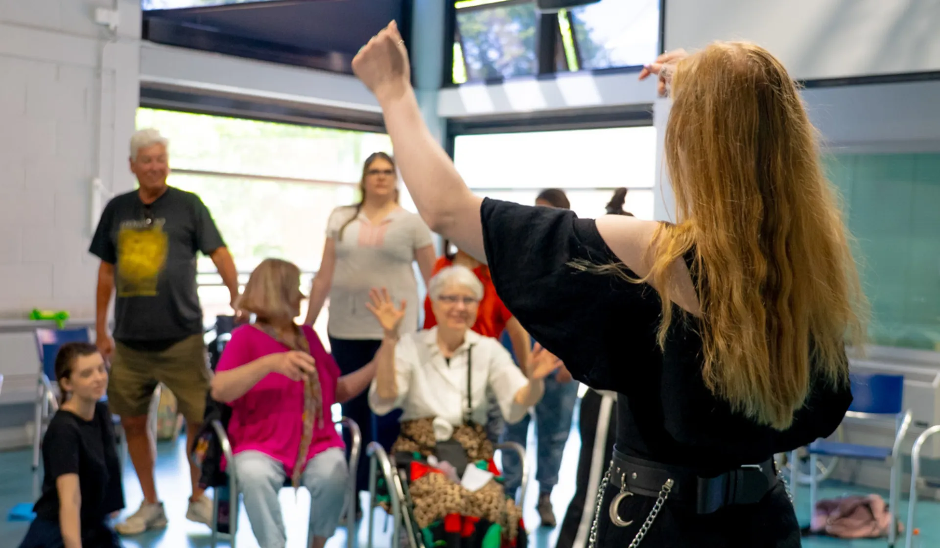 A woman conducting adults singing