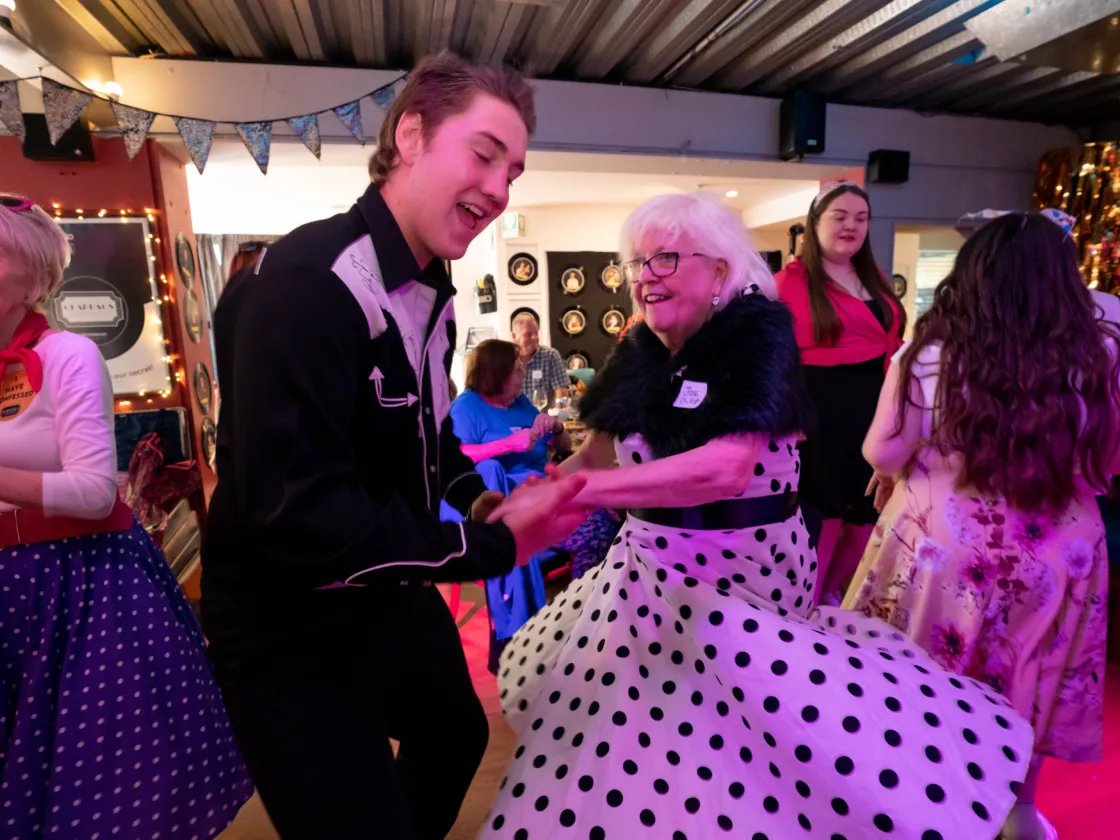young man and older lady dance together