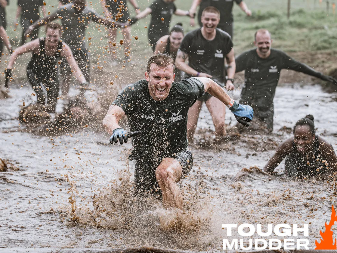 A man running through mud at Tough Mudder