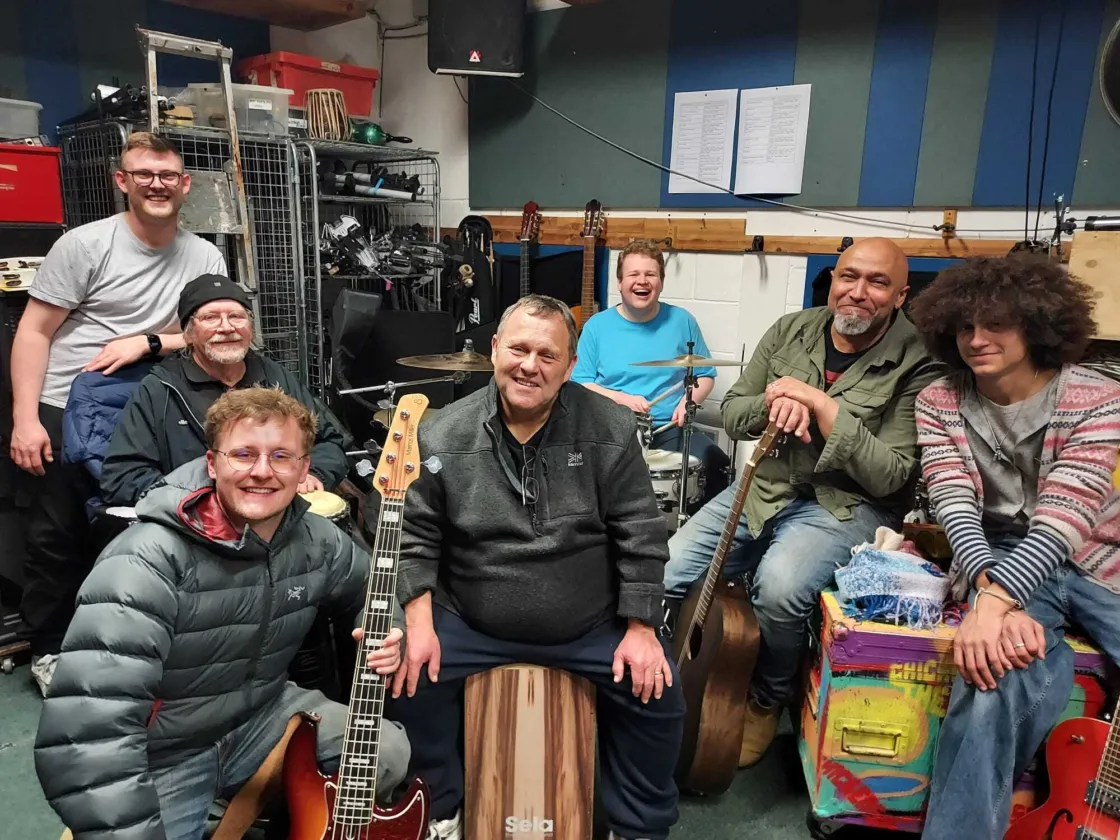 A group of musicians sitting together with instruments