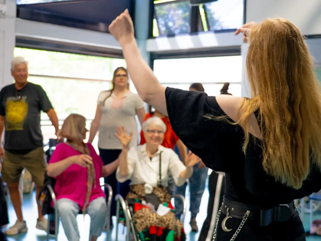 A woman conducting adults singing