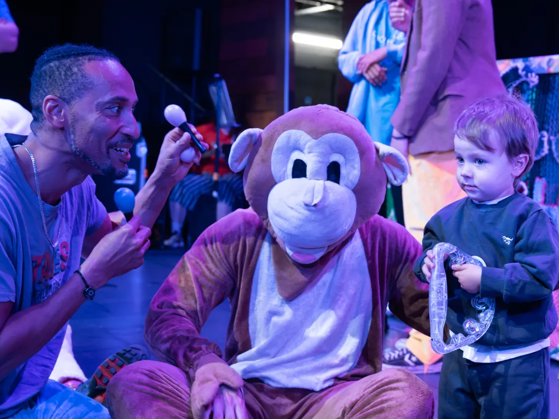 performer interacts with monkey and child