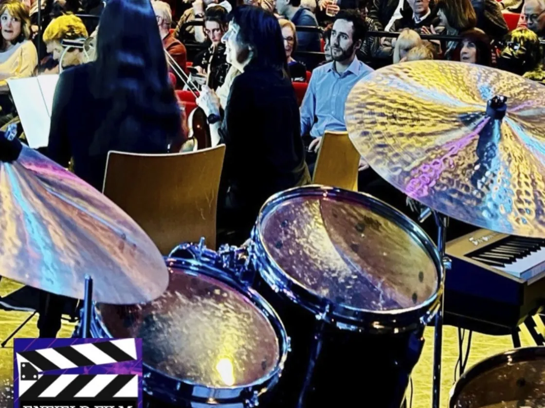 close up of a drum set with a blurry crowd in the distance
