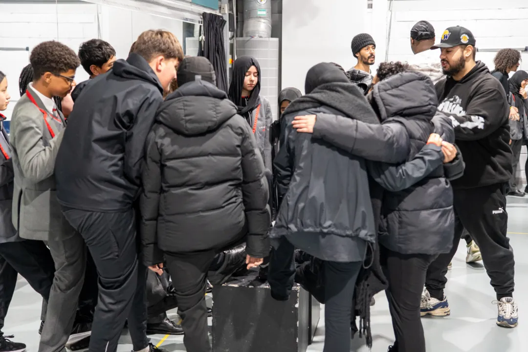 Group of students huddled togethr in workshops