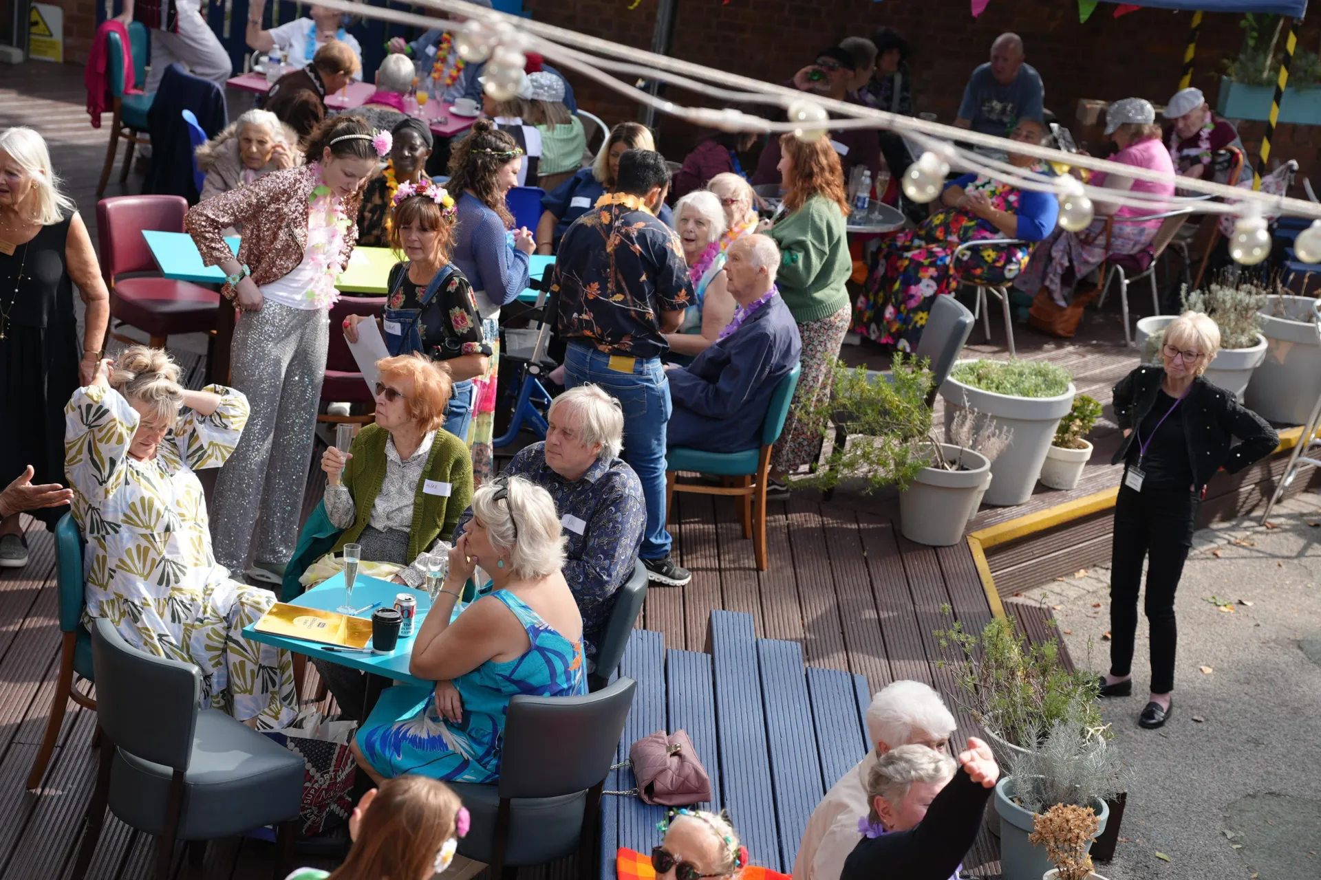 Gladstock attendees sitting with their drinks around tables on the outdoor terrace