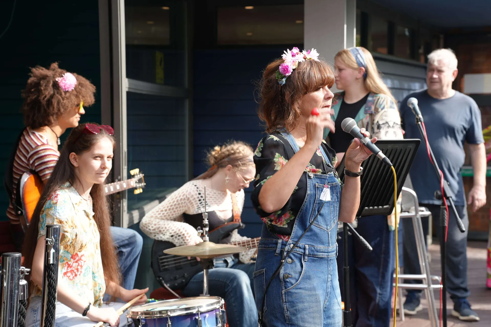 A group of Chickenshed musicians performing on the outdoor terrace with their instruments