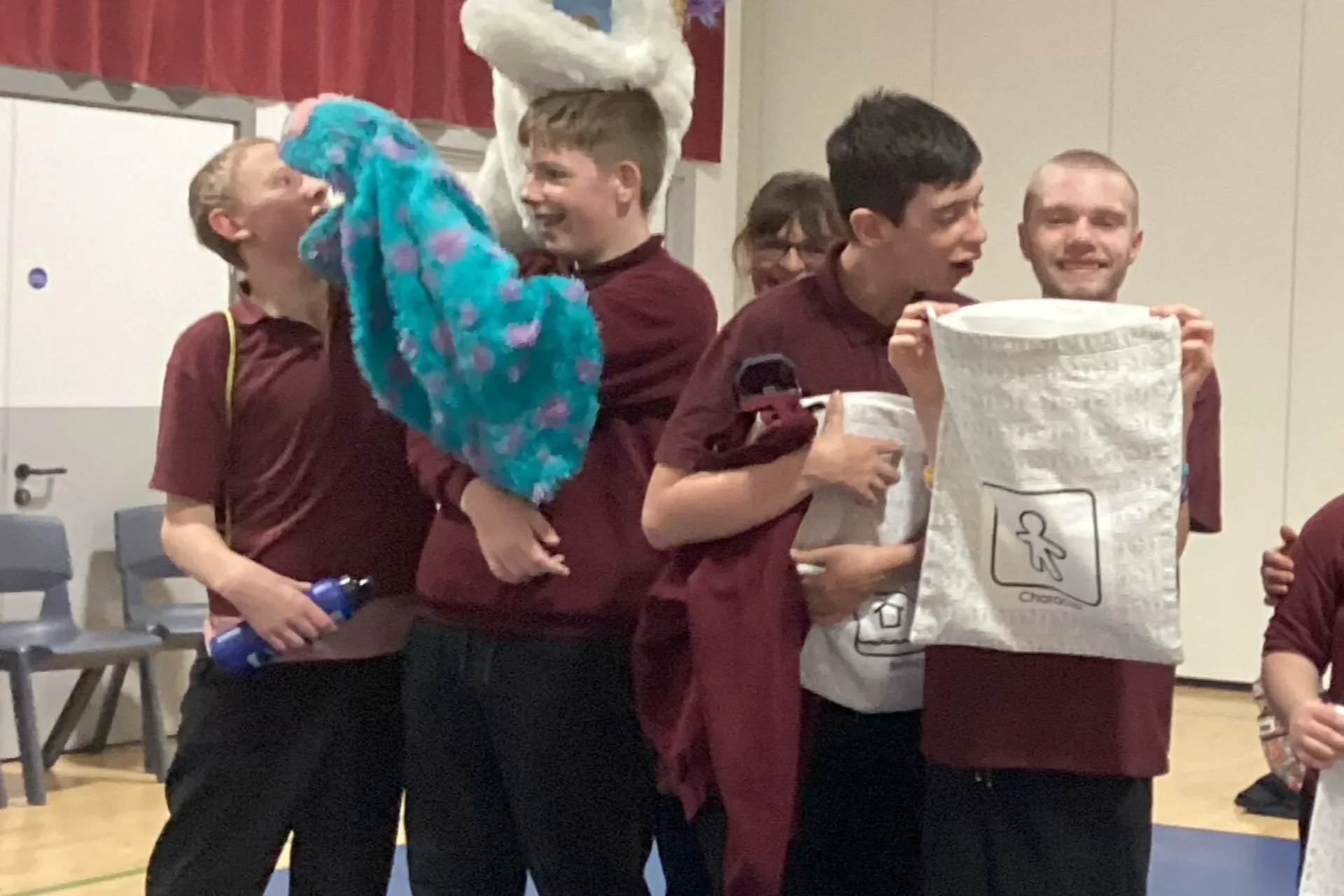 A group stood in a line together laughing with puppets