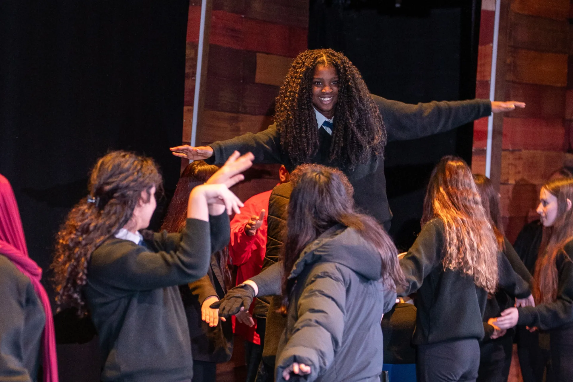 Girl standing on block in workshop smiling